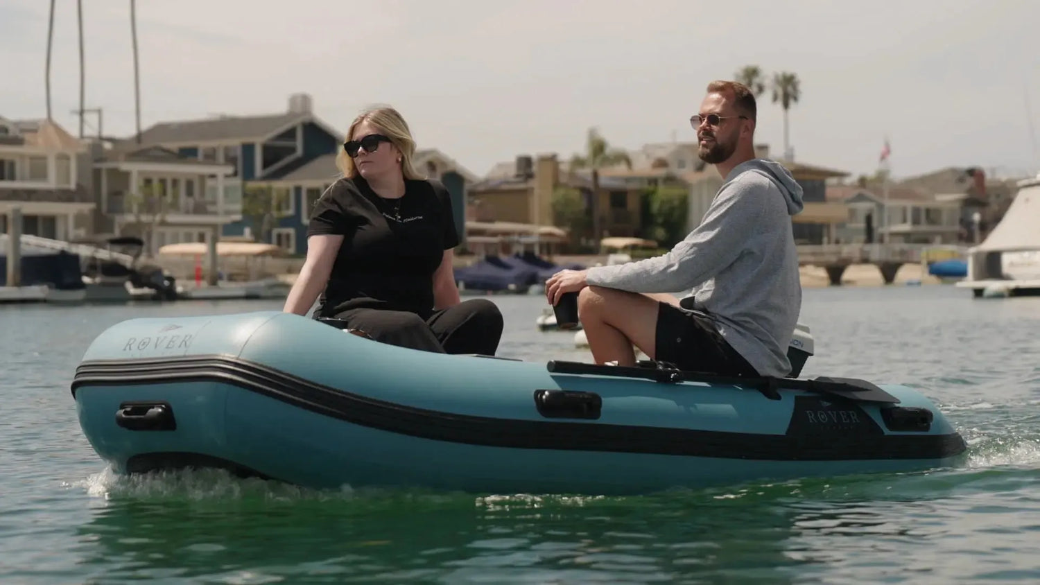 Two people riding customized inflatable dinghy on water