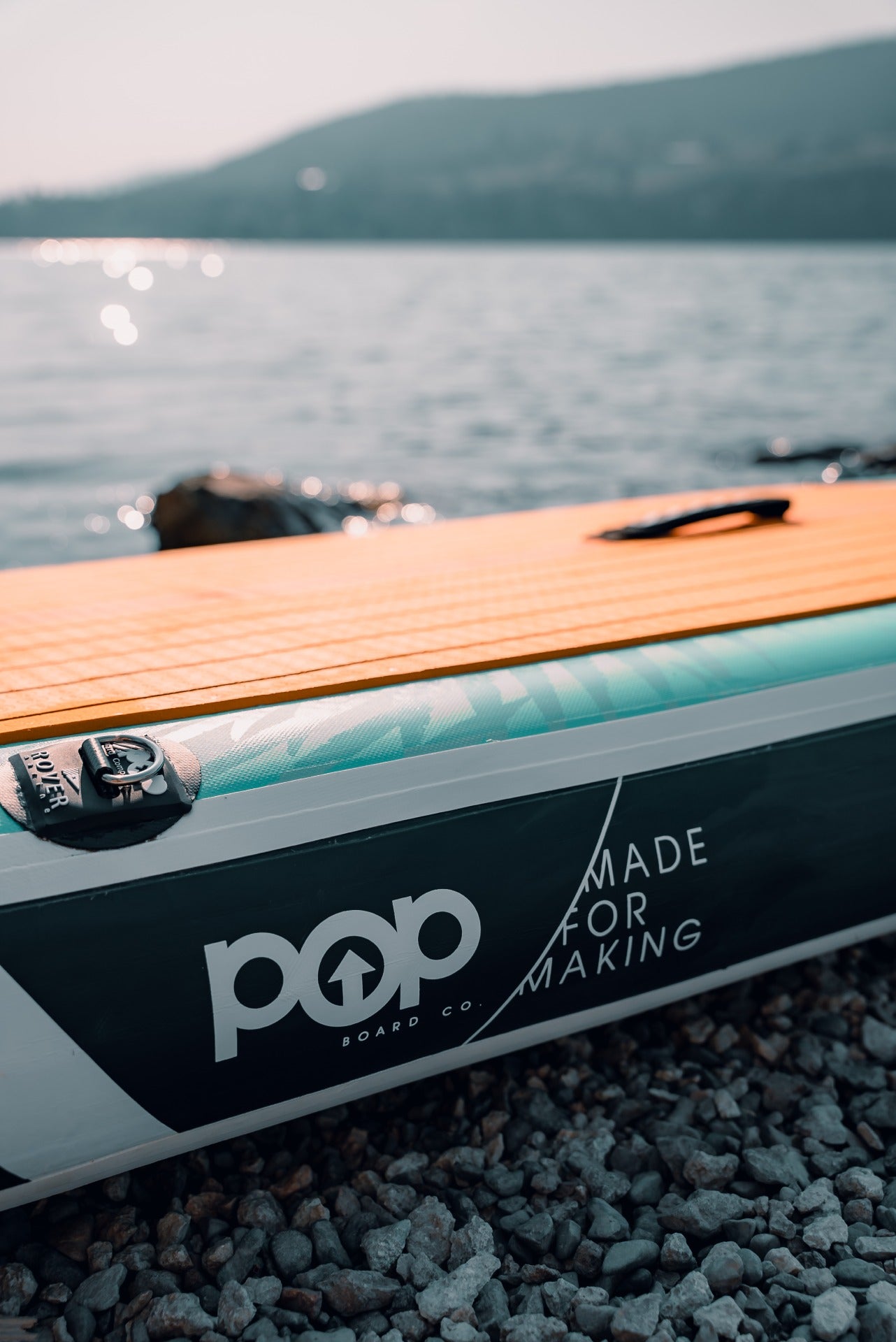 Close-up view of the 11'0" Yacht Hopper side rail, featuring the POP Board Co. logo and "Made for Making" slogan, along with the premium teak-style traction pad and reinforced seams.
