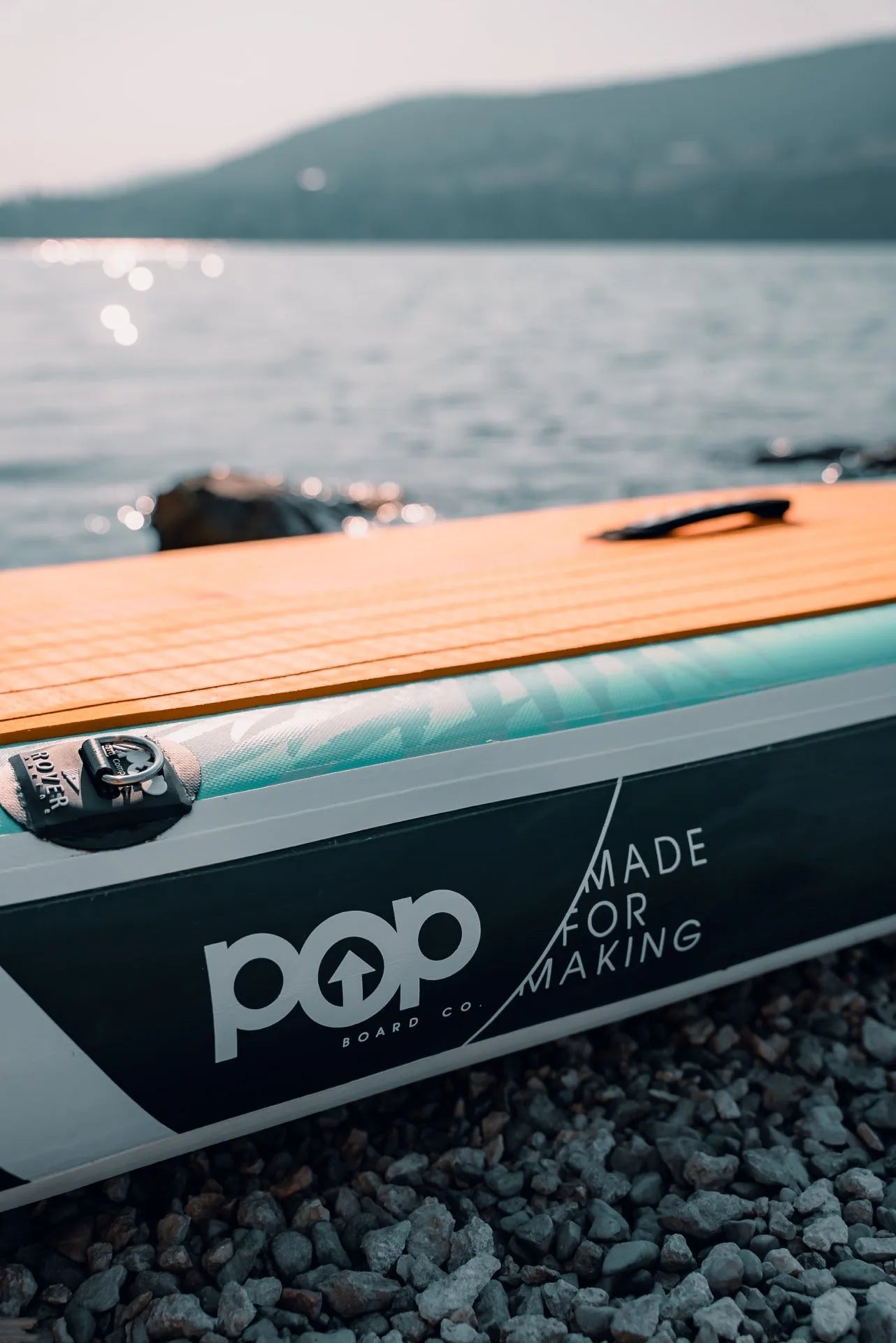 Close-up view of the 11'0" Yacht Hopper side rail, featuring the POP Board Co. logo and "Made for Making" slogan, along with the premium teak-style traction pad and reinforced seams.