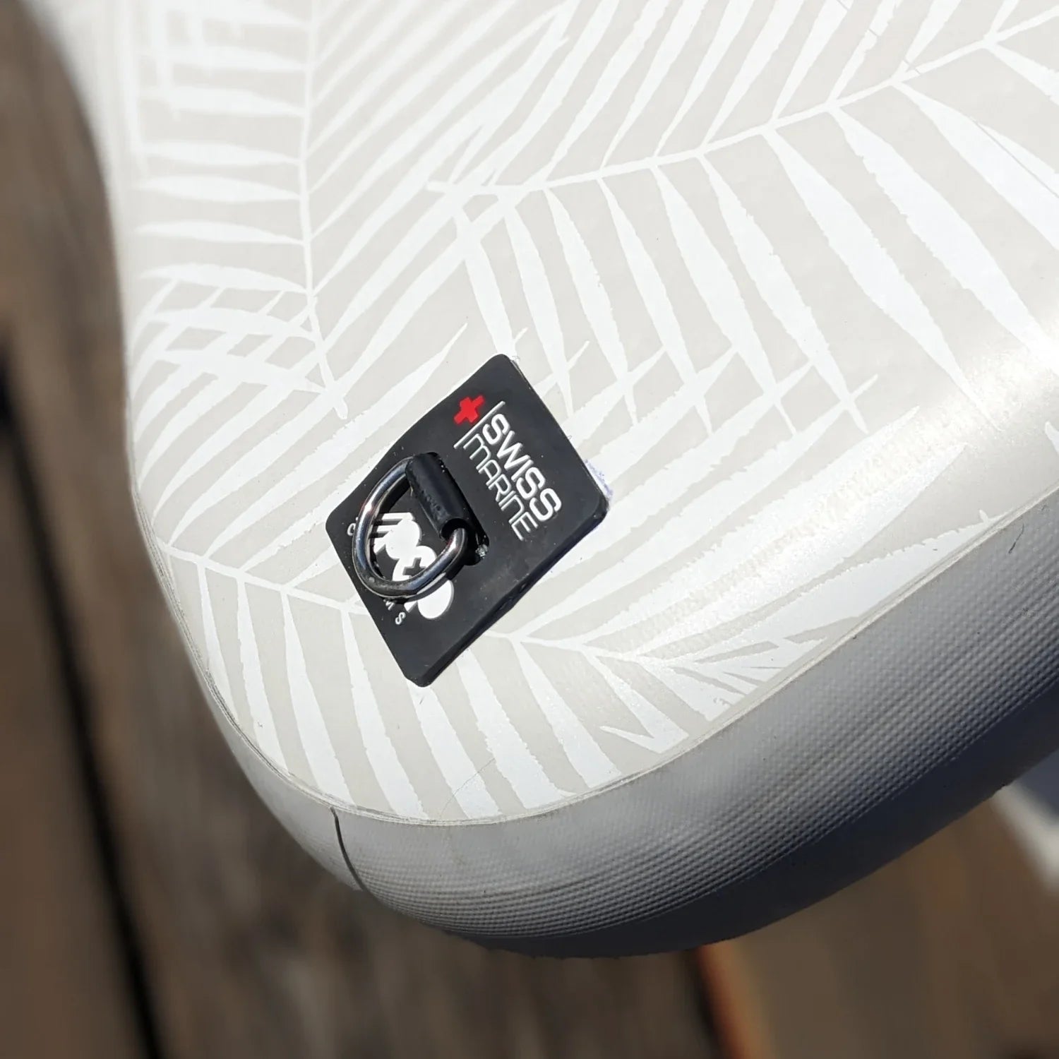 Close-up of D-ring with Swiss Marine label on POP Up Chair inflatable chair for secure anchoring and durability.