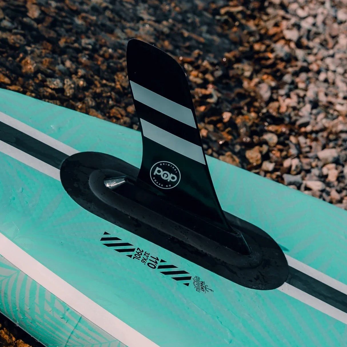 POP Yacht Hopper paddleboard with black striped fin system and teal leaf print design.
